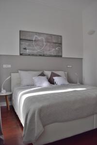 a bedroom with a white bed with a painting above it at Apartment Feel Good in Zagreb