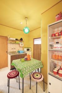 eine Küche mit einem Tisch und 2 Hockern in einem Zimmer in der Unterkunft Retoro Meieki 2號室 in Nagoya + 24 Fotos