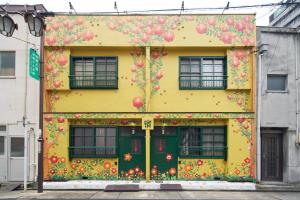 ein gelbes Gebäude mit darauf gemalten Blumen in der Unterkunft Retoro Meieki 2號室 in Nagoya