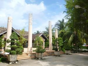 un bâtiment avec des colonnes et des plantes devant lui dans l'établissement Can Gio Resort, à Ấp Long An