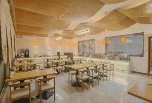 a dining room with wooden tables and chairs at Royal Bay Hotel in Towmoon