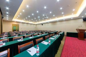 a large room with tables and chairs and a podium at Royal Bay Hotel in Towmoon