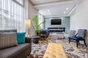een woonkamer met een bank en een tv bij The Champlain Waterfront Hotel, an Ascend Collection Hotel in Orillia