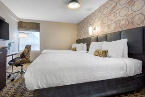 een hotelkamer met een groot bed en een bureau bij The Champlain Waterfront Hotel, an Ascend Collection Hotel in Orillia +25 foto's