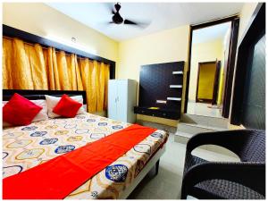 - une chambre avec un lit doté d'oreillers rouges et d'un miroir dans l'établissement Hotel Puri Himanshu CT - Near Sea Beach and Jagannath Temple - Fully Air Conditioned - Spacious Room - Excellent Service Recommended Book Quickly, à Purî