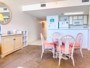 a dining room with a table and chairs and a kitchen at Verandas 602 in North Myrtle Beach