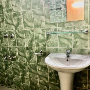 a bathroom with a sink and a mirror at Maya Eco Guest House in Dhaka