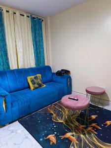 uma sala de estar com um sofá azul e uma mesa em Amara suites ongata Rongai em Ongata Rongai  mais 11 fotografias
