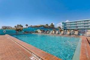 a large swimming pool with chairs and a hotel at Comfort Inn & Suites Ormond Beach Oceanfront in Ormond Beach