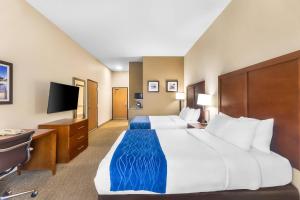a hotel room with a large bed and a desk at Comfort Inn & Suites Sikeston I-55 in Sikeston