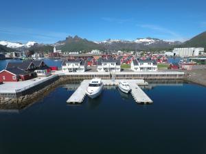 two boats docked at a dock in a harbor at Rorbuene Svolvær Havn in Svolvær +85 photos