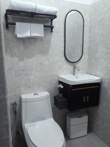 ein Badezimmer mit Toilette, Waschbecken und Spiegel in der Unterkunft GYANA House in Ubud + 8 Fotos