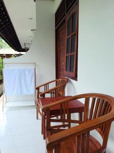 a room with three wooden chairs and a table at GYANA House in Ubud