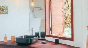 a bathroom with a black sink and a mirror at BambooJam Villa in La Ceiba
