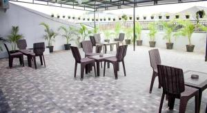 a patio with tables and chairs and palm trees at W Home Express Tebet in Jakarta