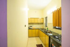 a small kitchen with yellow cabinets and a sink at Peeliyatt riverview stays in Cochin +6 photos
