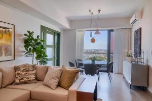 Una sala de estar con un sofá y un comedor. en ®{PANO~VIEW~Experience} @DowntownSD PoolGym2BR, en Ensanche Quisqueya