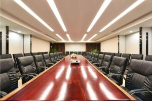 a conference room with a long table and leather chairs at PARK INN KUNMING AIRPORT in Kunming