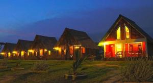 a row of houses with lights on them at night at Bestlife Eco Resort Mattala Airport in Maththala