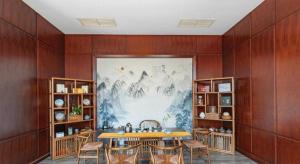 a dining room with a table and chairs and a painting at New Century Pujiang Hotel in Xiajizhai