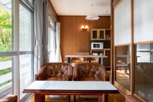 a dining room with leather chairs and a table at rinne 2nd living Nasu Forest in Wada