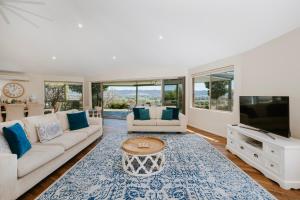 a living room with a couch and a tv at Allambie - Poolside Elegance in Mudgee Countryside in Mudgee