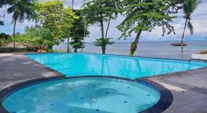 a large blue swimming pool next to the ocean at Asana Biak Papua Hotel in Fandoi