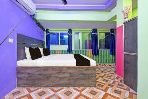 a bedroom with a bed with colorful walls at Hotel O Star Mall Kolkata Formerly Dreamland in Dohāri