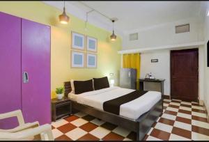 a bedroom with a king sized bed and colorful walls at Hotel O Palasuni Bridge Bhubaneswar Formerly Ganpat in Mancheshwar