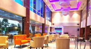 a lobby with chairs and tables in a building at G'Sign Hotel Banjarmasin in Sungai Lutus