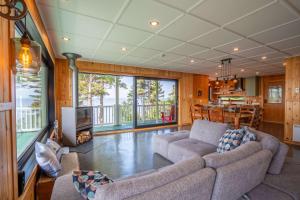 a living room with two couches and a kitchen at Spa Nature & Comfort - Chalet LRioux in Trois-Pistoles