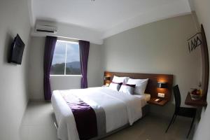 a hotel room with a bed and a window at Amantis Hotel in Demak +98 photos