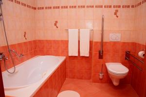 a bathroom with a tub and a toilet and a sink at Penzion Bocheta in Nový Jičín