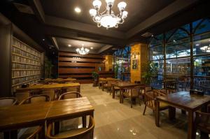 a restaurant with wooden tables and chairs and a chandelier at Hotel Floce in Pup'yŏng-dong