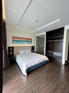 a bedroom with a large bed and a television at Sapphire home S2 in Ha Long