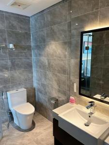 a bathroom with a toilet and a sink and a mirror at Sapphire home S2 in Ha Long +2 photos