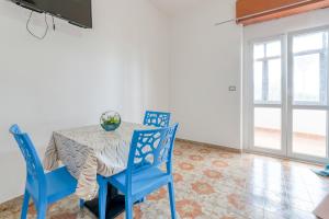 a dining room with a table and blue chairs at Villa Bludea - Salento in Torre Lapillo