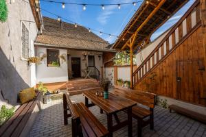 an outdoor patio with a wooden table and chairs at Casa Maya Transilvania in Sighişoara