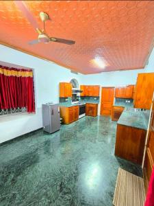 a large kitchen with wooden cabinets and a ceiling at Janiszel Heaven- A Zion Legacy in Putuppalli