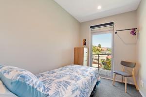 Un dormitorio con una cama y una silla y una ventana. en Waikawa Bay View - Waikawa Holiday Home, en Waikawa 24 fotos más