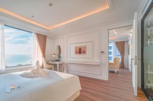 a white bedroom with a bed and a large window at Sea Soul Hotel in Nha Trang
