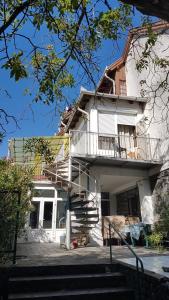 a white house with a staircase in front of it at Szatmári Vendégház in Badacsonytomaj