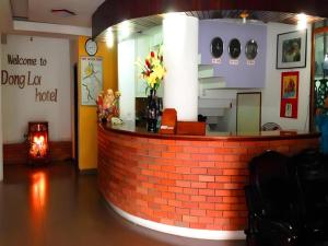 un comptoir en briques rouges dans une pièce avec des fleurs dans l'établissement Dong Loi Hotel, à Hue
