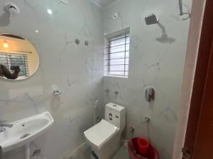 Un baño blanco con inodoro y lavabo. en Hotel O Airport Nest, en Dod Jāla