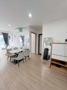 un salon avec une table, des chaises et un miroir dans l'établissement Thương Apartment 2, à Thôn Văn Dương