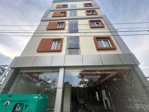 Un edificio alto con ventanas a los lados. en Hotel O Airport Nest, en Dod Jāla
