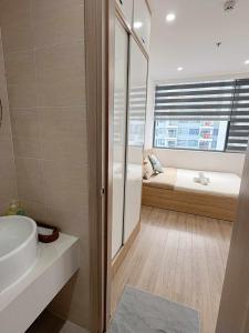 La salle de bains est pourvue d'un lavabo, d'un lit et d'une fenêtre. dans l'établissement Thương Apartment 2, à Thôn Văn Dương