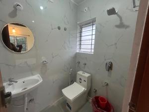 Un baño blanco con inodoro y lavabo. en Hotel O Airport Nest, en Dod Jāla 4 fotos más