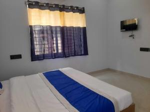 a bed in a room with a window at Hotel O Samrat Palace in Bārang +5 photos