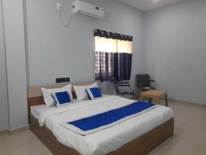 a bedroom with a large bed with blue pillows at Hotel O Samrat Palace in Bārang
